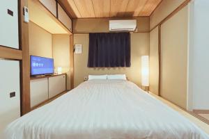 Ένα ή περισσότερα κρεβάτια σε δωμάτιο στο Vacation Rental -裏路地- 202 青い部屋 古馬場町