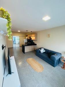 a living room with a blue couch and a kitchen at Casa Urban 56 - Pet Friendly - Vaga - Cama King in Belém