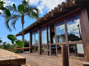 a house with glass windows and a palm tree at Bahia Outeiro das Brisas - Gibs' House in Porto Seguro