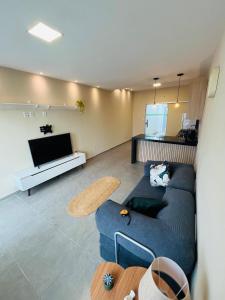 a living room with a blue couch and a tv at Casa Urban 56 - Pet Friendly - Vaga - Cama King in Belém