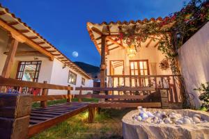 ein Haus mit einer Bank davor in der Unterkunft Espectacular cabaña con tina, fogata y cine in Villa de Leyva