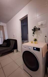 a small room with a bed and a washing machine at 803 Ponte laguna 1 dorm. CAMA QUEEN in Sao Paulo +55 photos