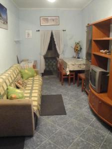 uma sala de estar com um sofá e uma televisão em Apartment Saric em Lovran