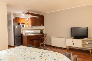 a kitchen with a television and a kitchen with a table at Comodo Depto Home Estudio IV in Santiago