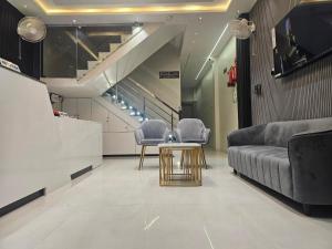 a living room with a couch and chairs and a table at Hotel Crystal Sarovar in Mirzāpur