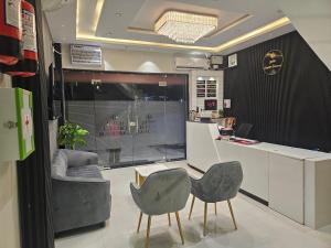 a room with two chairs and a table and a counter at Hotel Crystal Sarovar in Mirzāpur