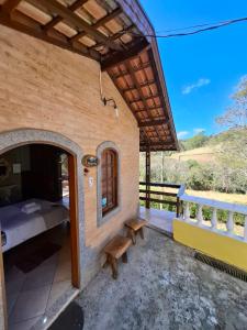 a guest house with a bedroom and a balcony at Chalés São Francisco I in Santo Antônio do Pinhal