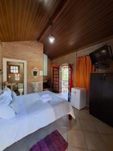 a bedroom with a large white bed in a room at Chalés São Francisco I in Santo Antônio do Pinhal