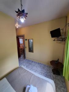 a bedroom with a bed and a flat screen tv at Chalés São Francisco I in Santo Antônio do Pinhal