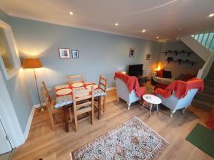 a living room with a table and chairs and a couch at Cosy cottage in the centre of Dursley in Dursley