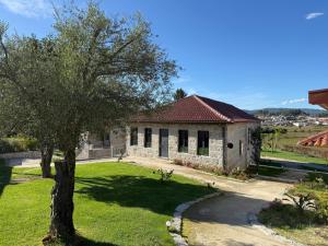 una pequeña casa con un árbol delante en Quinta de Cartas, 