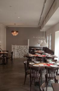 La Flamme Wertheim garni في فيرتهايم: مطعم فيه طاولات وكراسي في الغرفة