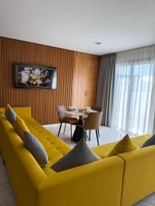 uma sala de estar com um sofá amarelo e uma mesa em Marina sweet em Tânger mais 50 fotografias