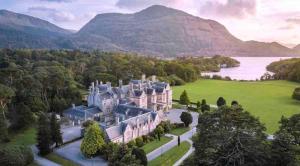 una vista aérea de una mansión con un lago y montañas en Reeks View Farmhouse, en Kilgobnet