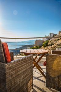a table and chairs on a patio with a view of the ocean at Viva B&B in Anavyssos