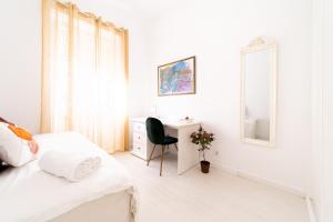 una camera da letto bianca con una scrivania e un letto di Peaceful 2-bedroom House with Garden at the heart of Benfica a Lisbona