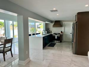 a kitchen with a table and a refrigerator at Luxury Seabreeze Retreat in Fort Myers Beach