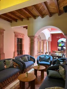 a living room with blue couches and tables at Hotel San Rafael in Querétaro