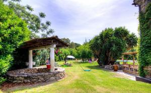 un jardin avec un belvédère et une aire de jeux dans l'établissement La Casalamadonna, à Santa-Lucia-di-Moriani