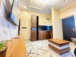 un soggiorno con televisione e tavolo di La Vintage Apartelle - Apartment Paris a Ikeja