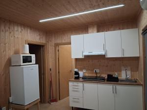 a kitchen with white cabinets and a microwave at Private Pool Douro River View Villa in Baião
