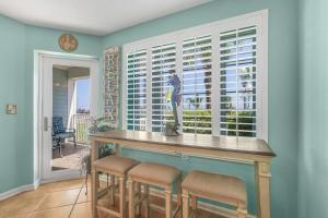 a dining room with a bar with stools in front of a window at Grand Caribbean 111 Beach View Condo pool views in Orange Beach +37 photos