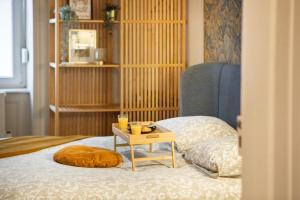 a bed with a table with a pillow on it at Zenora Loft Hot Tub & Arcade in Downtown in Mulhouse