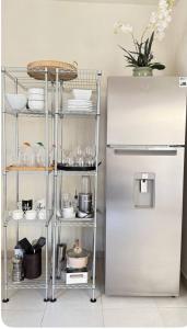 a kitchen with a metal shelf next to a refrigerator at Sweet Junior de Juliza in Hermosillo +41 photos
