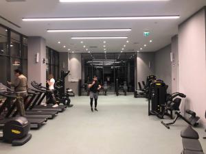 Un hombre caminando por un gimnasio con máquinas de correr. en BOULEVARD rentals, en Tashkent