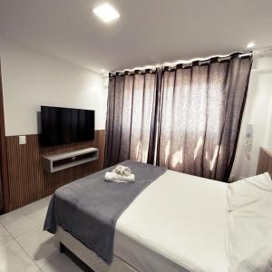 Nossa Senhora do LivramentoにあるParadise Flat 306.のベッドと薄型テレビのある寝室