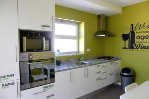 a kitchen with a sink and a microwave at UAU Hostel in Figueira da Foz