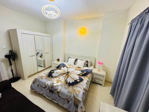 a bedroom with a bed with a flower blanket at شقة فندقية غرفة وصالة in Sharjah