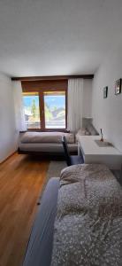 una camera da letto con due letti, una scrivania e due finestre di Switzerland New Year's Eve in a cozy little town a Lenk