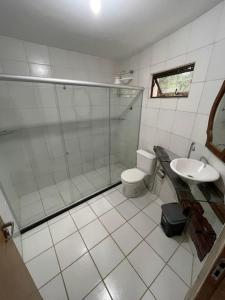a bathroom with a shower and a toilet and a sink at Sitio Bangue in Camaragibe +35 photos