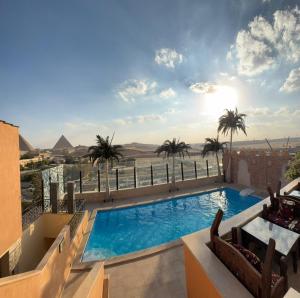 a swimming pool on top of a building with palm trees at 7 Gates Boutique Hotel Pyramids in Cairo