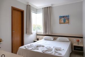 Un dormitorio con una cama con sábanas blancas y una ventana. en Aguas da Serra Flat Terra Thermas, en Rio Quente 25 fotos más