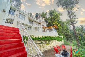 a house with red chairs in front of it at Zostel Homes Mussoorie in Mussoorie