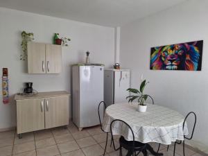 a dining room with a table and a refrigerator at 3 Kitnets in Rio das Ostras