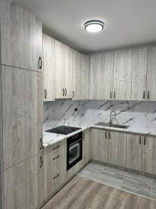 a kitchen with wooden cabinets and marble counter tops at LUX APARTMENS GLIGA Lux 14 in Sombor