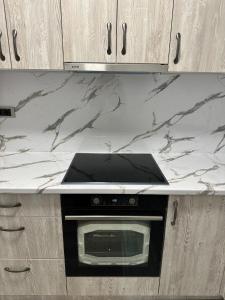 a white counter top with a microwave in a kitchen at LUX APARTMENS GLIGA Lux 14 in Sombor +3 photos