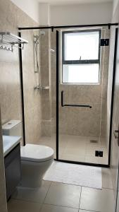 une salle de bain avec douche et WC avec porte vitrée dans l'établissement Newrise Gardens Apartments, à Nairobi