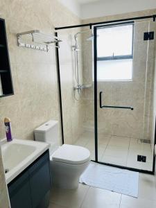 une salle de bain avec une douche, des toilettes et un lavabo dans l'établissement Newrise Gardens Apartments, à Nairobi 18 autres photos