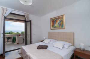 a bedroom with a bed and a balcony with a table at Luxury Rooms Near the Beach1 in Split