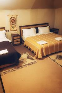 a bedroom with two beds and a rug at Luxury camp excurions in Merzouga +7 photos