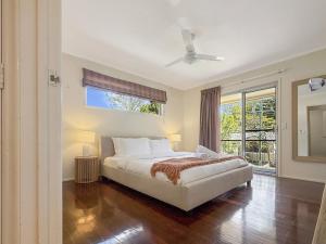 Un dormitorio con una cama y un ventilador de techo. en Spacious Family Retreat with Pool Pet friendly, en Jindalee