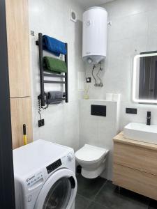 a bathroom with a washing machine and a toilet at Олімпік парк, м Бориспільська 5 хв пішки, генератор на будинку in Kyiv