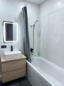 a bathroom with a sink and a tub and a mirror at Олімпік парк, м Бориспільська 5 хв пішки, генератор на будинку in Kyiv