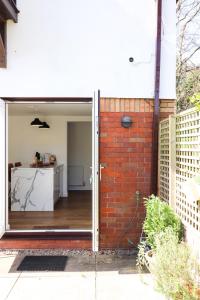 an open door into a kitchen with a brick wall at The Coachhouse by Solace Stays in Bassaleg
