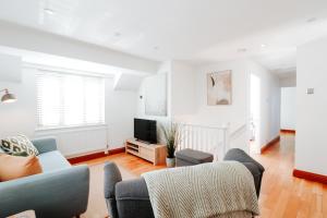 a living room with a couch and a tv at The Coachhouse by Solace Stays in Bassaleg