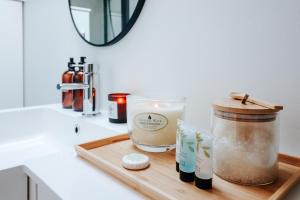 a cutting board with a candle and a jar on a counter at The Coachhouse by Solace Stays in Bassaleg +61 photos